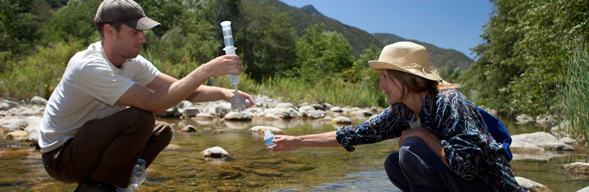 Two Santa Barbara Channelkeeper team members collecting water samples in the Ventura River.