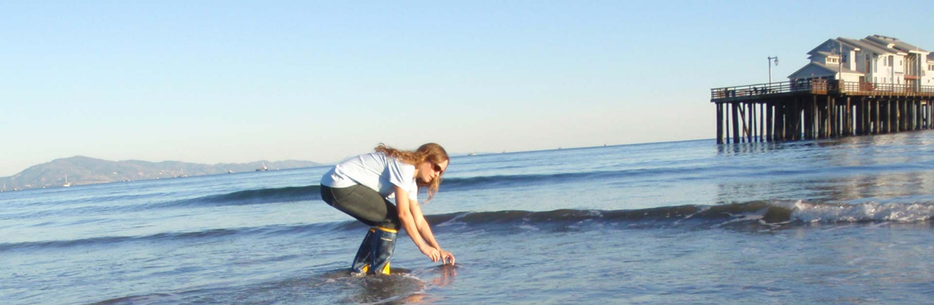 Santa Barbara Channelkeeper team member collecting water samples in the surf at a local beach for testing.